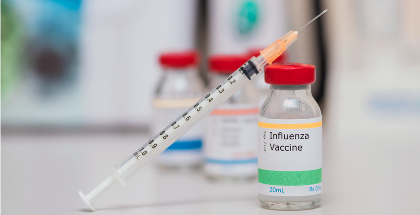 influenza vaccination concept with syringe in vaccine vial and o